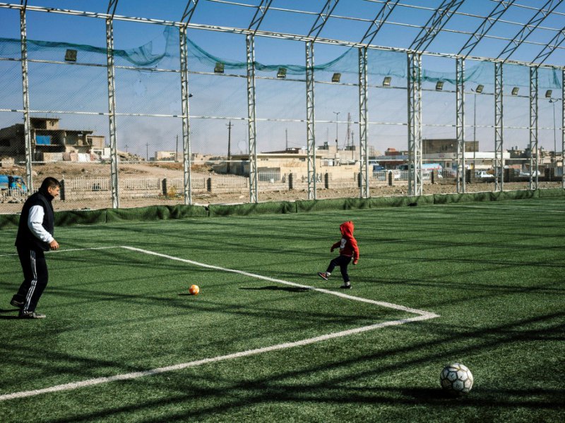 Un Irakien joue au foot avec un enfant à Mossoul, le 11 janvier 2017 - Dimitar DILKOFF [AFP]