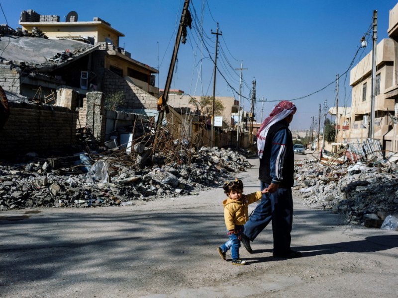 Un Irakien avec un enfant à Mossoul, le 11 janvier 2017 - Dimitar DILKOFF [AFP]