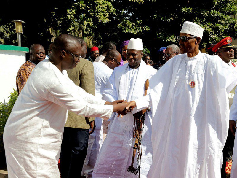 Une photo fournie par la présidence nigérienne le 13 janvier 2017, montre le président nigérian Muhammadu Buhari (D) serrant la main du nouveau président élu de Gambie, Adama Barrow (G), en présence du président gambien Yahya Jammeh (C) à Banjul - Handout [NIGERIAN PRESIDENCY/AFP]