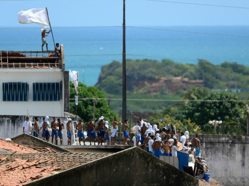 Un groupe de prisonniers déployant des drapeaux sur le toit délabré du plus grand centre pénitencier de l'État de Rio Grande do Norte, le 16 janvier 2017. - ANDRESSA ANHOLETE [AFP]