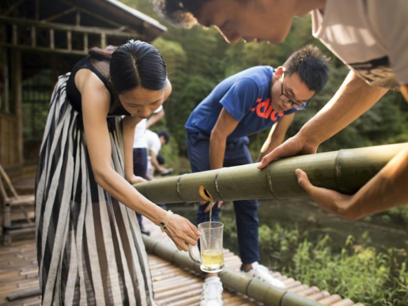 De l'alcool s'écoule dans un verre, après avoir veilli plusieurs années dans un tronc de bambou, le 30 juillet 2016 à Yibin, en Chine - FRED DUFOUR [AFP]