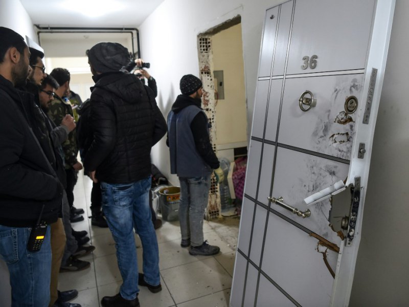 La police devant la porte d'entrée arrachée de l'appartement occupé par l'auteur de la tuerie du Reina, le 17 janvier 2017 - OZAN KOSE [AFP]