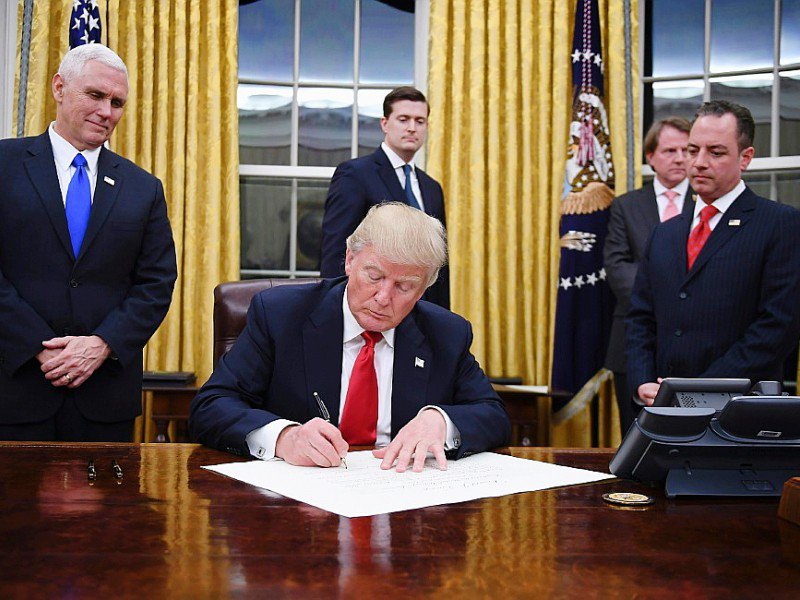 Donald Trump signe ses premiers décrets de président des Etats-Unis, le 20 janvier 2017 dans le bureau ovale de la Maison Blanche, à Washington - JIM WATSON [AFP]