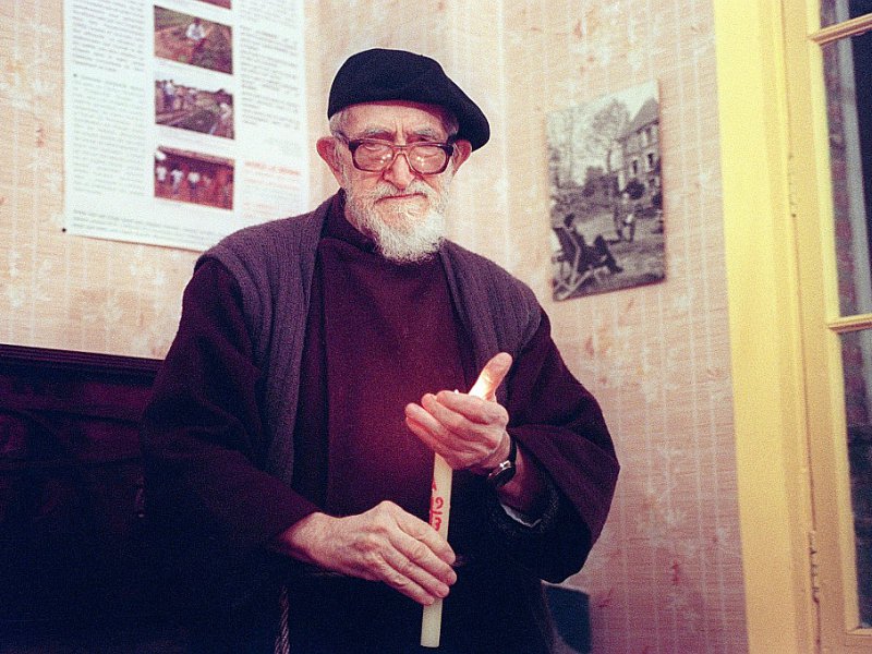 L'Abbé Pierre, tenant une bougie, à la Fondation Emmaüs à Esteville en janvier 1993 - JOEL SAGET [AFP/Archives]