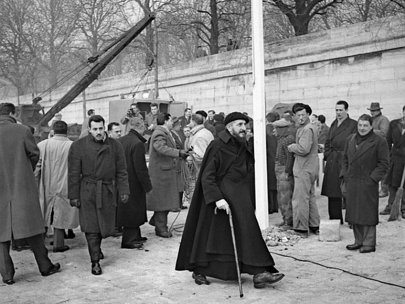 L'abbé Pierre supervise le 20 février 1956 l'installation de nouveaux logements conçus par l'architecte Jean Prouvé pour les sans-abris - [AFP/Archives]
