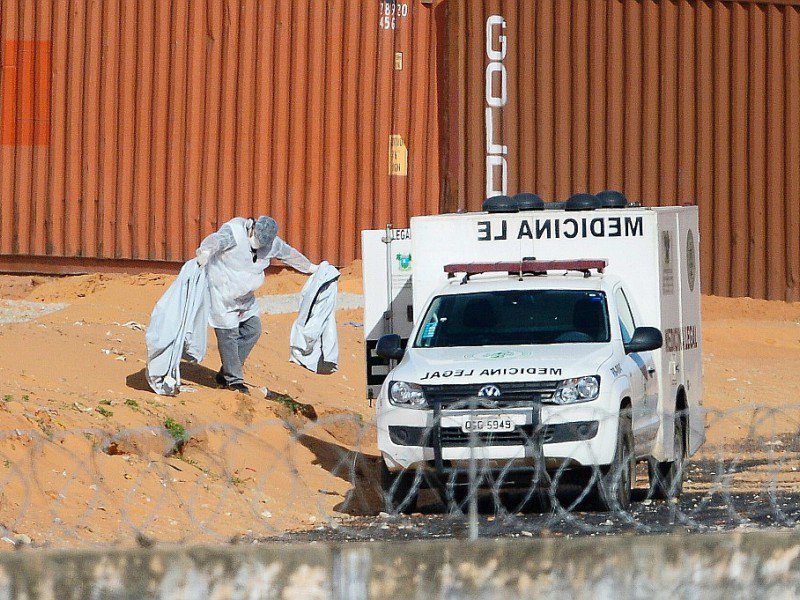 Un médecin légiste emporte des restes de corps découverts dans la prison d'Alcaçuz, près de Natal, le 21 janvier 2017 au Brésil - ANDRESSA ANHOLETE [AFP]