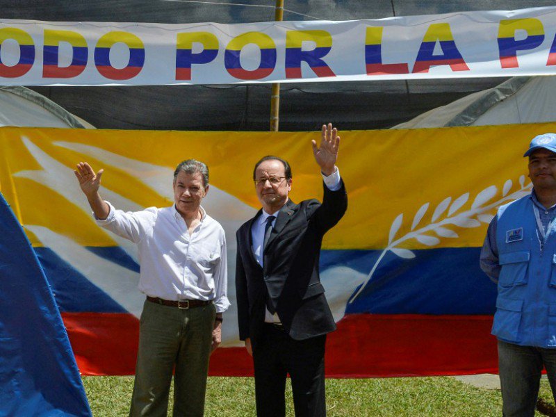 Les présidents colombien, Juan Manuel Santos, et français, François Hollande, sous une bannière "tout pour la paix" lors d'une visite dans un camp de désarmement des Farc, le 24 janvier 2017 à Caldono en Colombie - Cesar CARRION [Colombian Presidency/AFP]