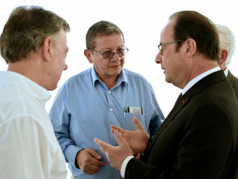 Le président François Hollande (D) accompagné de son homologue colombien Juan Manuel Santos (G) s'entretient avec  un représentant des Farc, Pablo Catatumbo, lors d'une visite dans un camp de désarmement des Farc, le 24 janvier 2017 à Caldono en Colo - STEPHANE DE SAKUTIN [AFP]