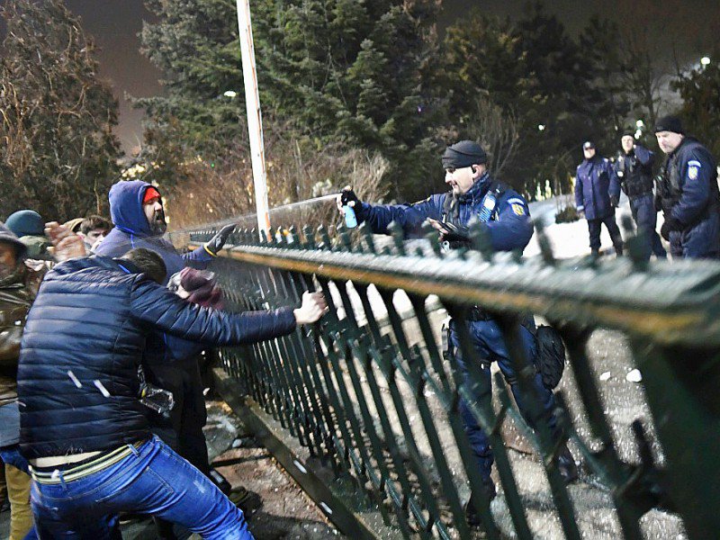 Un gendarme gaze des manifestants afin de les empêcher de pénétrer dans l'enceinte du siège du gouvernement à Bucarest, le 31 janvier 2017 - DANIEL MIHAILESCU [AFP]