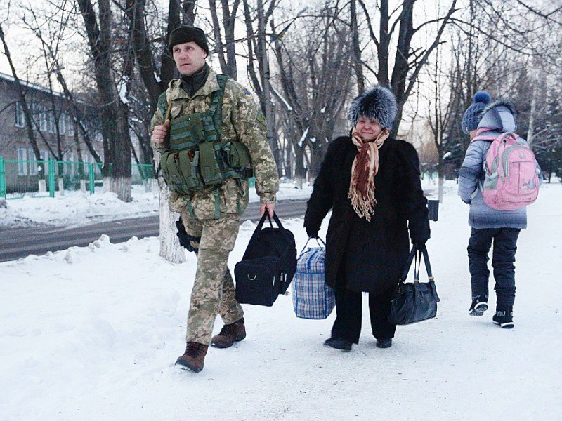 Un soldat ukrainien aide une femme âgée à transporter ses effets personnels vers une tente dressée pour les résidents de la ville d'Avdiïvka, le 31 janvier 2017 - Aleksey FILIPPOV [AFP]