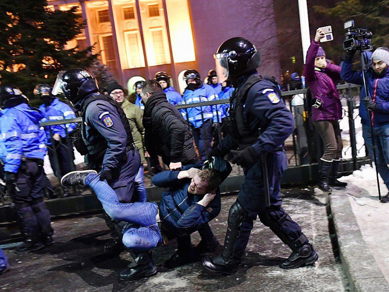Un manifestant est emmené par la police anti-émeute, le 1er février 2017 à Bucarest - DANIEL MIHAILESCU [AFP]