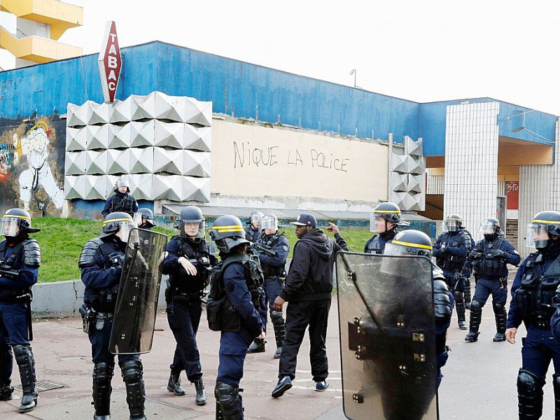 Policiers devant un graffiti "Nique la police" au pied de l'antenne du commissariat située au cœur de la cité des 3.000 à Aulnay-sous-Bois, le 6 février 2017 - FRANCOIS GUILLOT [AFP]