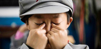 Un écolier chinois se masse les yeux, exercice traditionnel avant la reprise des cours l'après-midi, à l'école Yang Dezhi, dans la province du Guizhou, le 7 novembre 2016 - Fred DUFOUR [AFP]