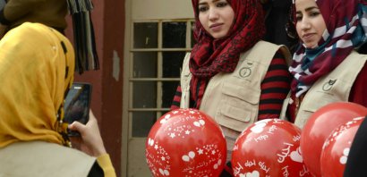 Des membres de l'association Génération Renaissance distribue des ballons pour la Saint-Valentin dans une école à Mossoul le 14 février 2017 - STRINGER [AFP]