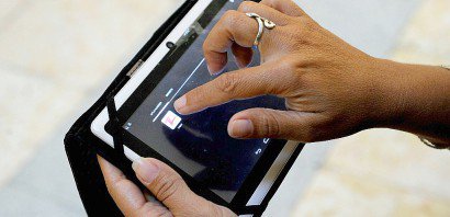 Une Cubaine utilise sur sa tablette "Zapya", une application permettant d'échanger des fichiers à courte distance, sans connexion filaire ni internet, le 14 février 2017 à La Havane - YAMIL LAGE [AFP]