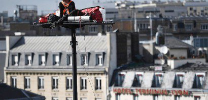 L'artiste Abraham Poincheval sur une plateforme située à 18 mètres de hauteur devant la gare de Lyon à Paris le 26 septembre 2016 - CHRISTOPHE ARCHAMBAULT [AFP/Archives]