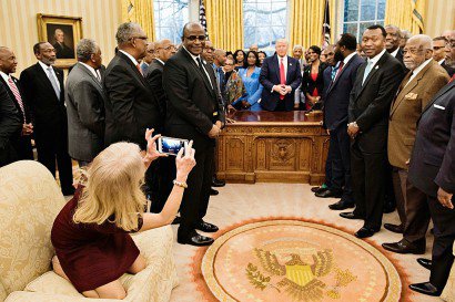 La conseillère du président américain Donald Trump, Kellyanne Conway (g), agenouillée sur un sofa pour prendre une photo du président, le 27 février 2017 dans le Bureau Ovale de la Maison Blanche - Brendan Smialowski [AFP]