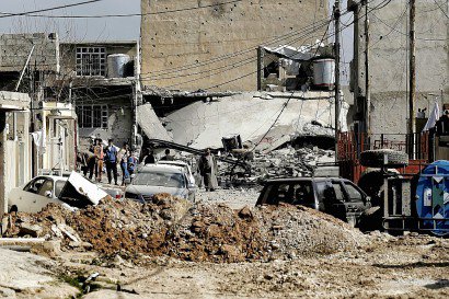 Des habitants au milieu d'un quartier en ruines le 1er mars 2017 à Mossoul - ARIS MESSINIS [AFP]