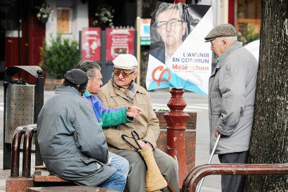 Des habitants de la ville devant une affiche électorale de Jean-Luc Mélenchon le 3 février 2017 à Carmaux - PASCAL PAVANI [AFP]