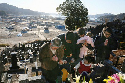 Des Japonais se recueillent sur la tombe de leurs proches le 11 mars 2017 à Otsuchi - JIJI PRESS [JIJI PRESS/AFP]