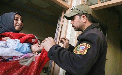 Une Irakienne demande de l'aide pour son son bébé malade à un membre des forces de sécurité le 10 mars 2017 à Mossoul - AHMAD AL-RUBAYE [AFP]