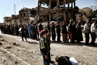 Des civils en file d'attente pour une distribution de nourriture le 10 mars 2017 à Mossoul - ARIS MESSINIS [AFP]