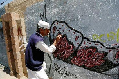 Le temps d'une journée, le mur sud de l'enceinte de l'Université de Sanaa a servi de musée à ciel ouvert, attirant de nombreux habitants de la capitale fatigués par la situation dans leur pays. - Mohammed HUWAIS [AFP]