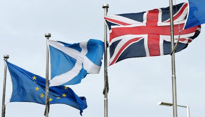 Le drapeau écossais, la croix de Saint-André, flotte sur le Parlement écossais à Edimbourg entre le drapeau européen et le drapeau britannique, le 13 mars 2017 - Lesley Martin [AFP]