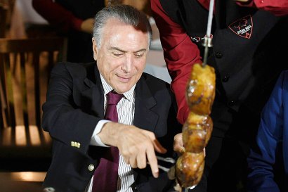 Le président brésilien Michel Temer lors d'un barbecue auquel des ambassadeurs étrangers étaient invités après une réunion  d'urgence sur le démantèlement d'un réseau de commercialisation de viande avariée au Brésil, le 19 mars 2017 à Brasilia - EVARISTO SA [AFP]