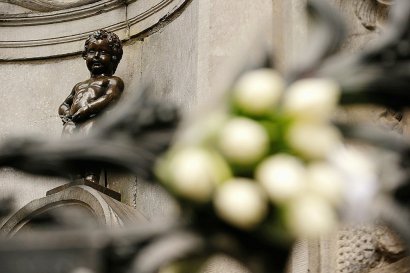 Des fleurs déposées au pied de la statue du Manneken Pis, au lendemain des attentats de Bruxelles, le 23 mars 2016 - KENZO TRIBOUILLARD [AFP/Archives]