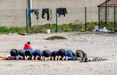 Des Kurdes irakiens prient dans un camp de réfugiés à Grande-Synthe, en France, le 21 mars 2017 - PHILIPPE HUGUEN [AFP]