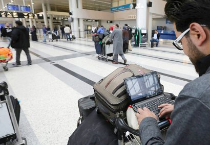 Un passager syrien devant son ordinateur portable avant de prendre son vol pour les Etats-Unis à Amman, le 22 mars 2017 - ANWAR AMRO [AFP]