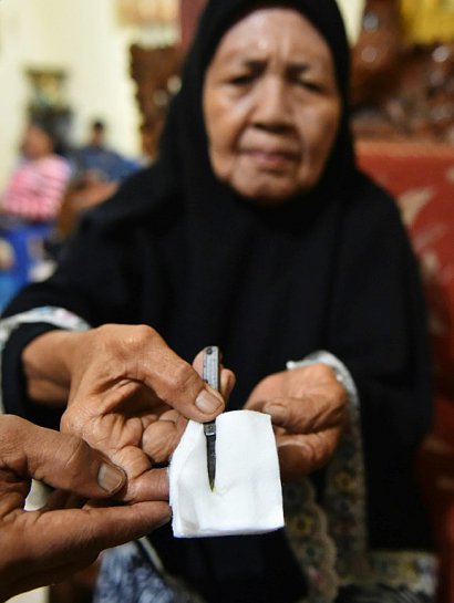 Une guérisseuse indonésienne montre un couteau avec lequel elle pratique l'excision à Gorontalo, en Indonésie, le 20 février 2017 - BAY ISMOYO [AFP]