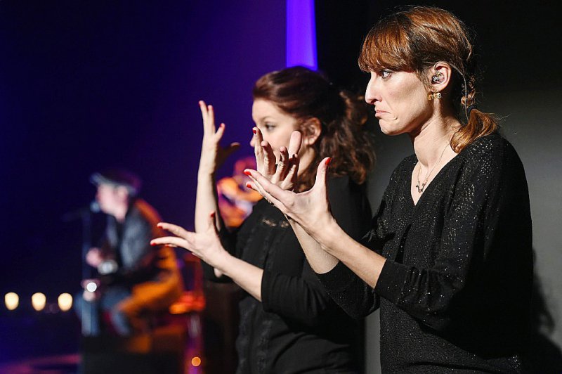 Rachel Fréry (G) et Séverine Michel (D), du collectif "Deux mains sur scène", interprètes professionnelles en langue des signes française (LSF), lors du concert d'Yves Jamait à Sausheim dans la banlieue de Mulhouse (région Grand Est) le 23 mars 2017 - SEBASTIEN BOZON [AFP/Archives]