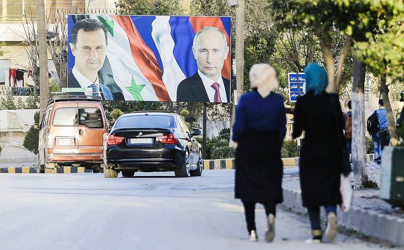 Les portraits du présiden syrien Bachar al-Assad et du président russe Vladimir Poutine, le 9 mars 2017, à Alep, en Syrie - JOSEPH EID [AFP/Archives]