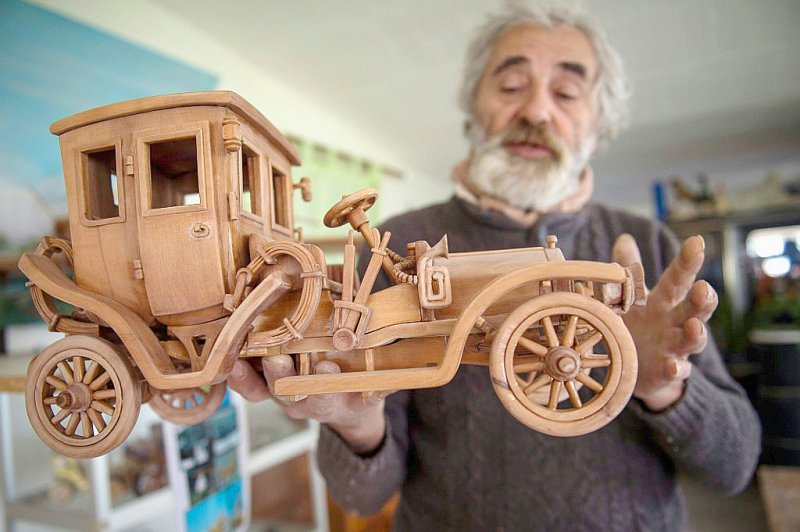 Le 20 mars 2017, à Loches, Michel Robillard présente un modèle réduit de voiture en bois - GUILLAUME SOUVANT [AFP/Archives]