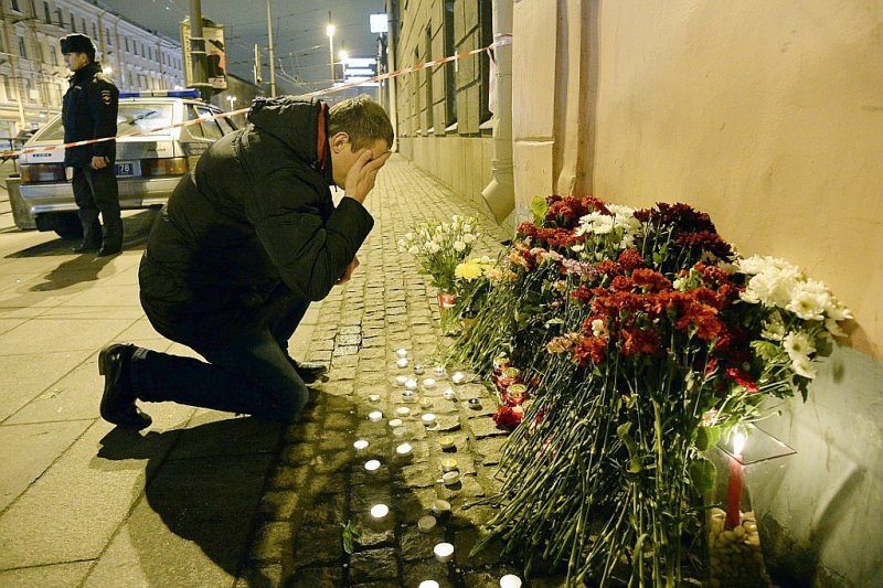 Un homme se recueille après avoir déposé des fleurs en mémoire aux victimes d'un attentat dans le métro, le 3 avril 2017 à Saint-Pétersbourg - Olga MALTSEVA [AFP]