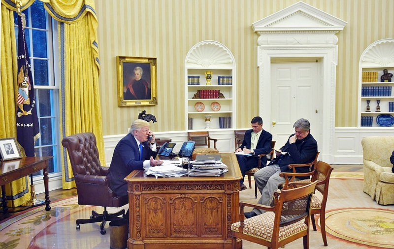 Le président américain Donald Trump (g)dans le bureau ovale en compagnie de ses conseillers Steve Bannon (d) et Michael Flynn (c) le 28 janvier 2017 - Mandel Ngan [AFP/Archives]