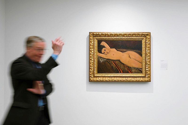 Le curateur Lukas Gloor devant le "Nu couché" d'Amedeo Modigliani, tableau qui figure parmi les oeuvres de la collection Bührle présentées pour la première fois à Lausanne, à la Fondation de l'Hermitage - Fabrice COFFRINI [AFP]