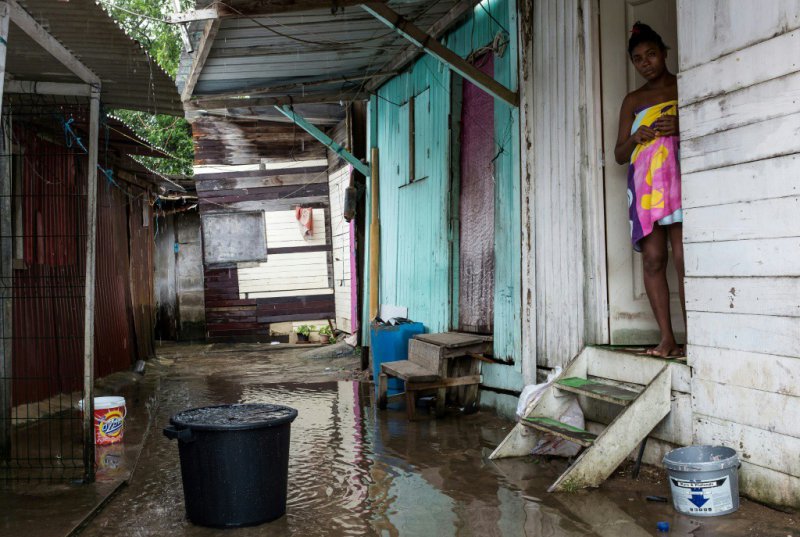Une femme à l'entrée de sa maison dans le bidonville "la Matine" à Cayenne le 6 avril 2017 - jody amiet [AFP]