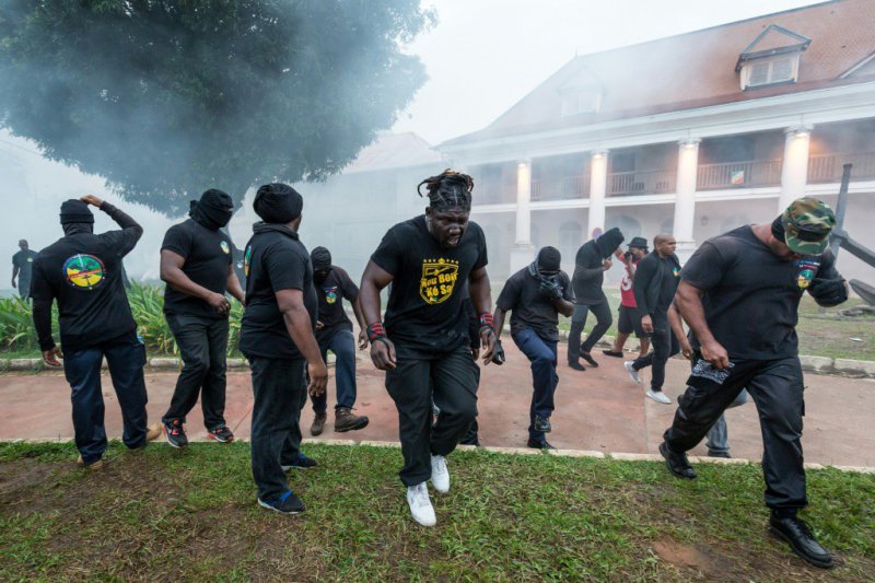 Des membres du collectif des "500 frères" fuient des tirs de gaz lacrymogène lors d'une manifestation devant la préfecture de Cayenne, le 7 avril 2017 en Guyane - jody amiet [AFP]