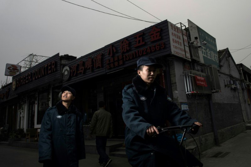 Des forces de l'ordre patrouillent dans un "hutong" à Pékin le 22 mars 2017 - Fred DUFOUR [AFP]