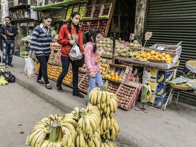 Des Egyptiennes passent devant un étal de fruits, dans une rue du quartier de la Choubra, le 11 avril 2017 au Caire - KHALED DESOUKI [AFP]