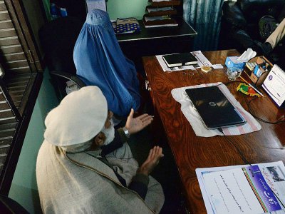 Nadia, une femme afghane avec son père lors d'un entretien dans le bureau de son avocat à Jalalabad le 16 janvier 2017 - NOORULLAH SHIRZADA [AFP]