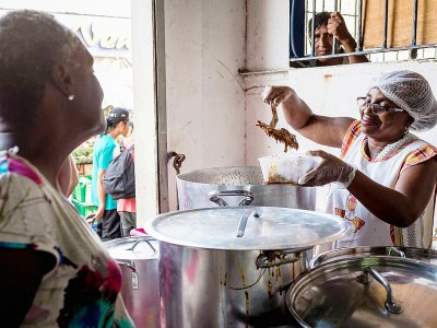 Une femme vend de l'Awara, un plat traditionnel uniquement cuisiné à Pâques, le 15 avril 2017 à Cayenne, en Guyane - jody amiet [AFP]