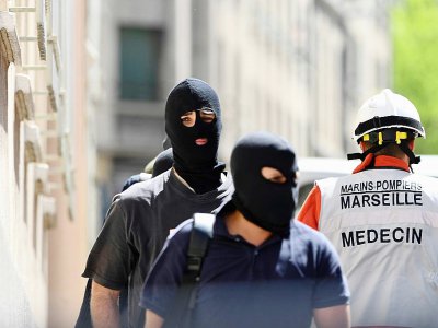 Des membres de la police judiciaire et un pompier à Marseille le 18 avril 2017 - boris HORVAT [AFP]