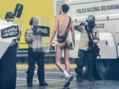 Un manifestant devant des policiers vénézuéliens, à Caracas, le 20 avril 2017 - JUAN BARRETO [AFP]