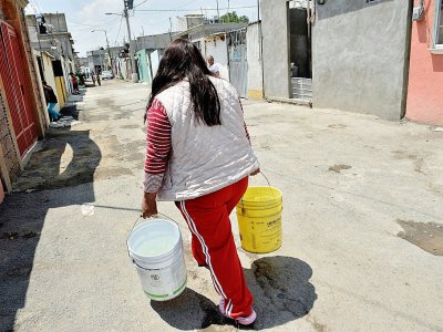 Une femme porte des sceaux remplis d'eau à Mexico, le 19 avril 2017 - YURI CORTEZ [AFP]
