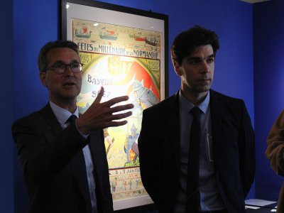 Deux des commissaires de l'exposition commentent les panneaux.