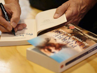 Pierre Lemaitre dédicace un livre au salon international du livre de Bogota, le 28 avril 2017 - Raul ARBOLEDA [AFP]